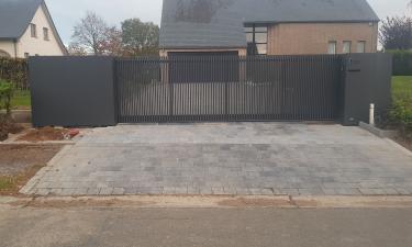 Moderne schuifpoort met verticale kokers en vaste panelen - Faimes