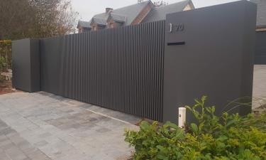 Moderne schuifpoort met verticale kokers en vaste panelen - Faimes