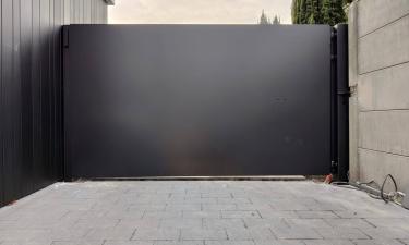 Strakke gesloten aluminium design poort uit lamellen motief - Zonhoven